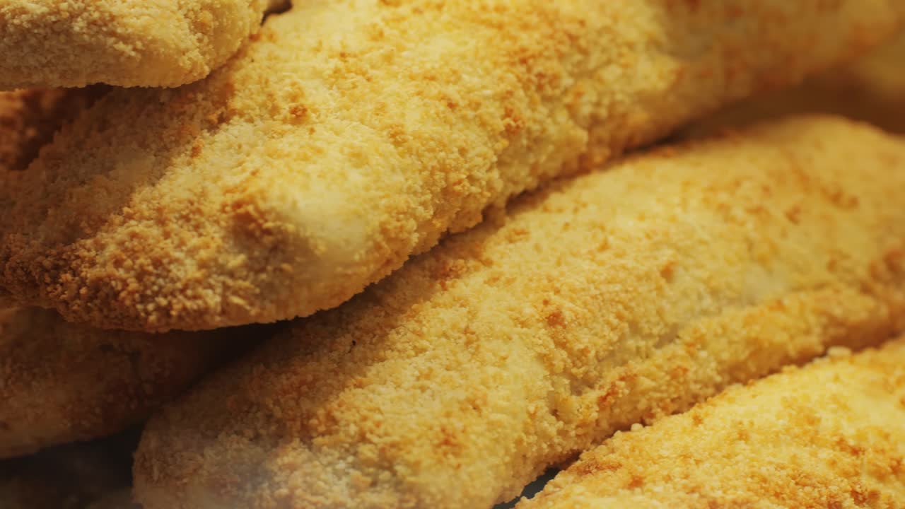 A large stack of freshly baked homemade empanadas beautifully arranged and displayed with a golden, crispy crust