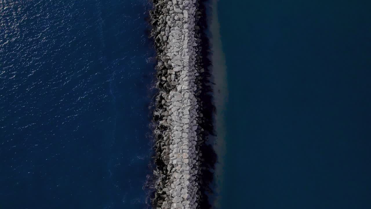 푸른 바다 물과 모래톱을 분리하는 부두를 따라 버드아이 뷰
