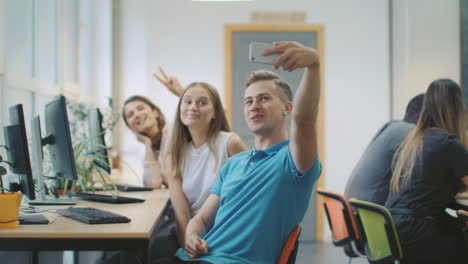 smiling man making group photo at coworking space. happy team posing on camera