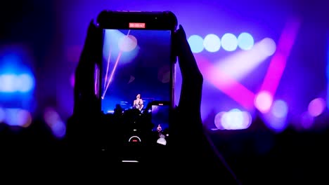 videorecording the performance of a singer on stage with a smartphone