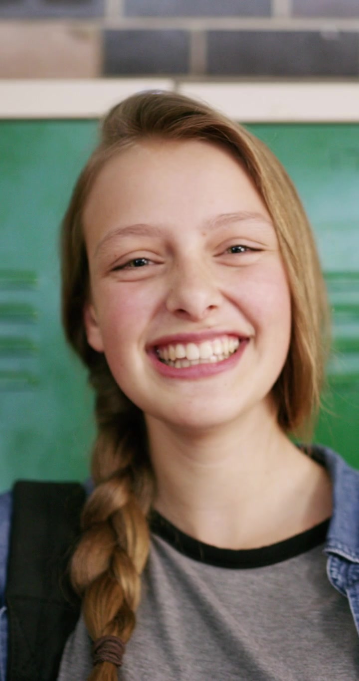 Happy Teenage Girl Laughing in School Hallway