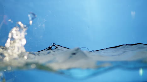 dynamic slow-motion close-up of blue waves on a water surface, perfect for illustrating the refreshing qualities of drinking water.