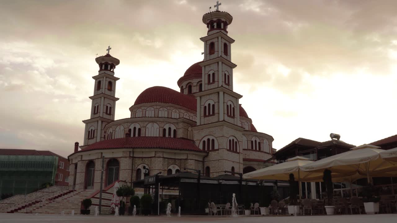 catedral de korca en albania con fuentes en la plaza pavimentada en la mañana nublada