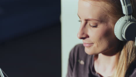 woman listens to music and uses digital tablet enjoys