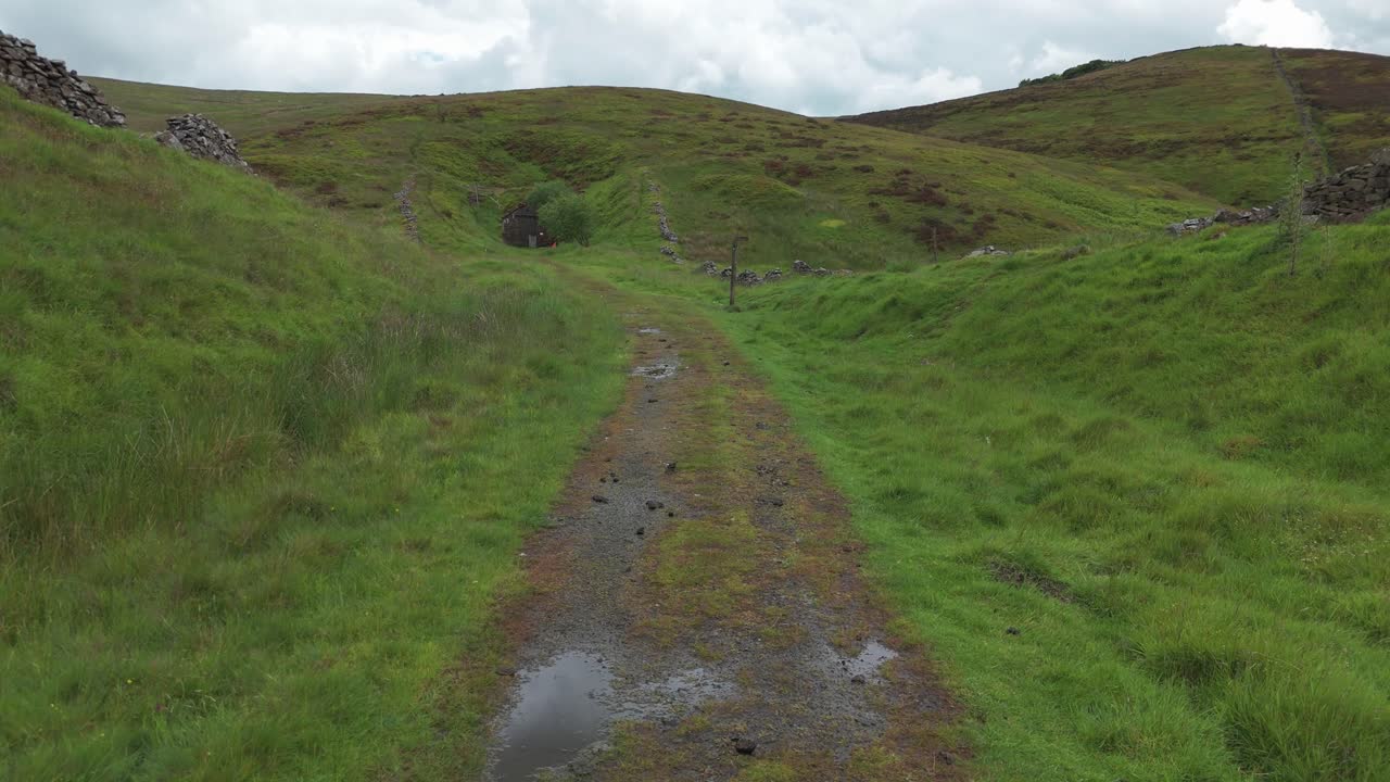 vista aérea de una carretera húmeda vacía en el parque nacional del distrito peak de derbyshire, inglaterra