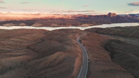 Wüstenstraße,-Umgeben-Von-Sträuchern-Und-Felsen,-Die-Sich-Zum-Colorado-River-Windet