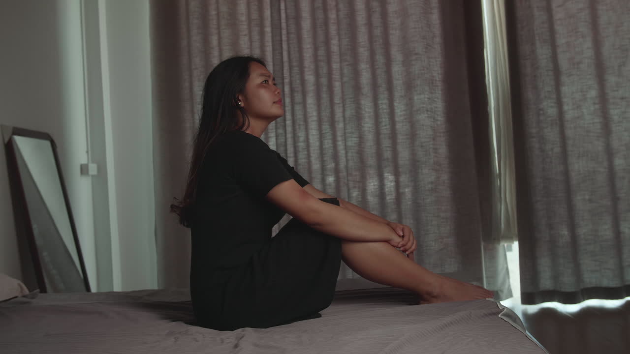 Young Woman Depressed And Stressed Sitting On The Bed