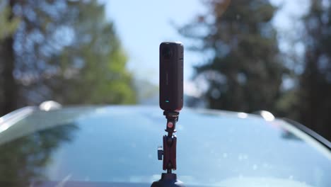 cámara de acción insta360 x3 en el exterior del coche rojo