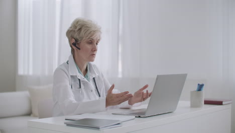 female professor of medicine is lecturing online from her office  using laptop with internet connection