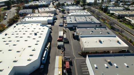 aerial drone flyover industrial buildings and warehouse rooftops