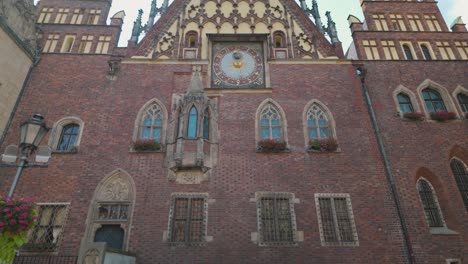 wroclaw town hall in poland, featuring its historic astronomical clock. the architectural details reflect gothic style. tilt up shot