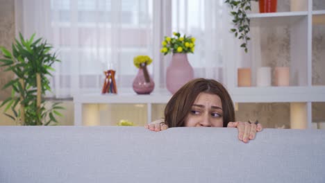 mentally ill schizophrenic young woman is hallucinating at home, she is uneasy and afraid.