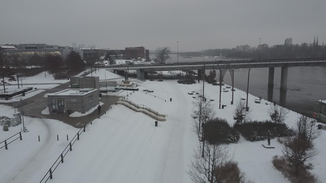 폴란드 바르샤바의 눈 덮인 강변이 다리와 교통량이 많은 차를 통해 보이는 드론 비디오