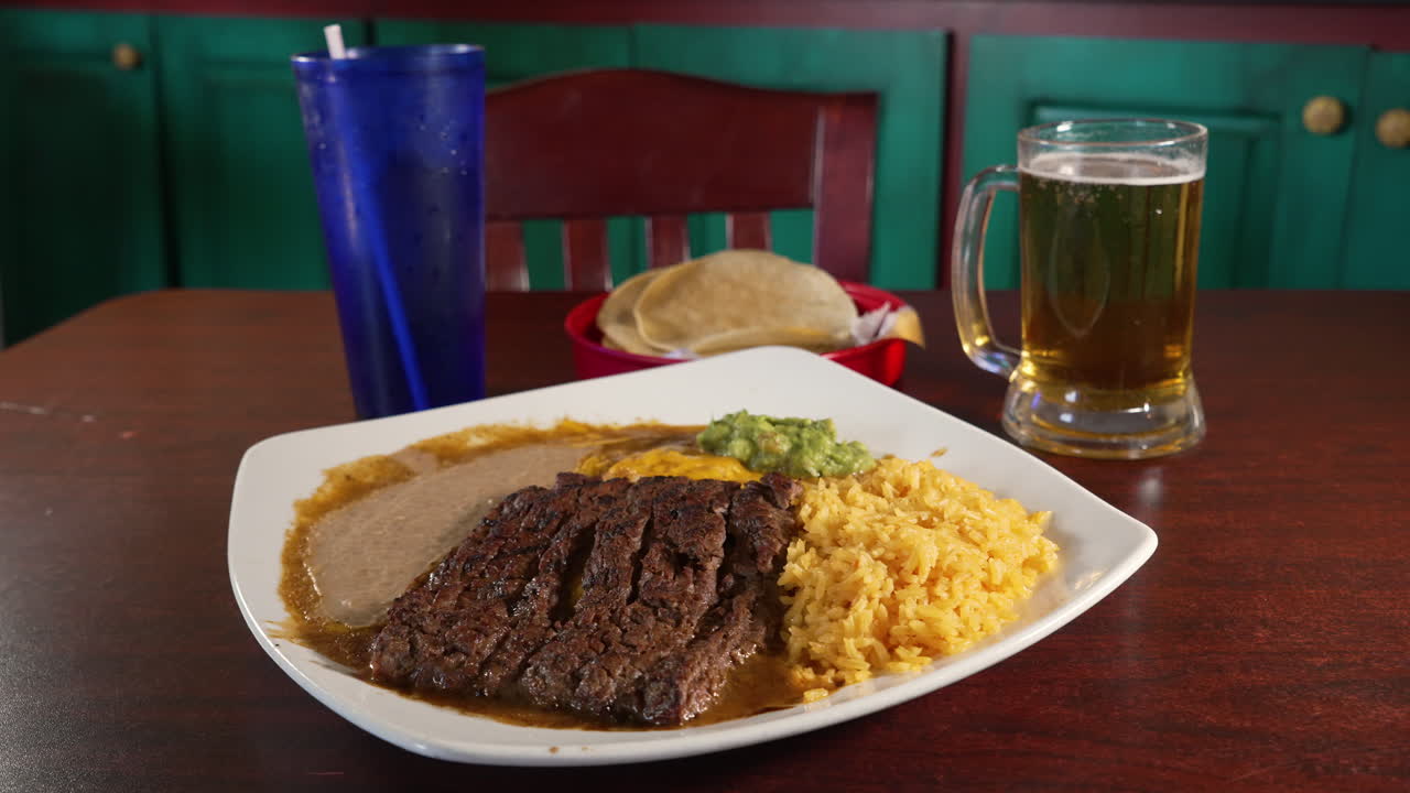 Enchiladas tampiquena topped with carne asada grilled skirt steak refried beans spanish rice paired with beer and corn torillas, slider 4K