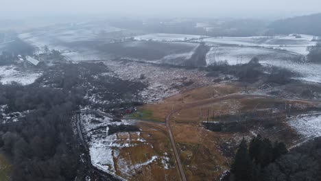 Aerial-View-Revealing-First-Snow-Landscape-on-Grey,-Misty-Day