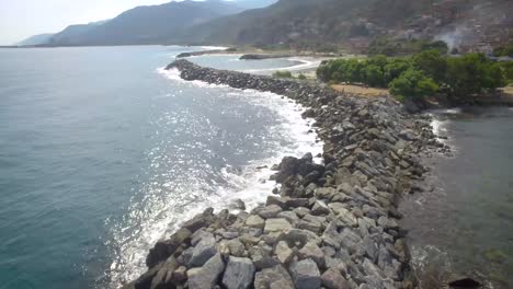 birds eye view of a rock breakwater on the green and calm caribbean sea