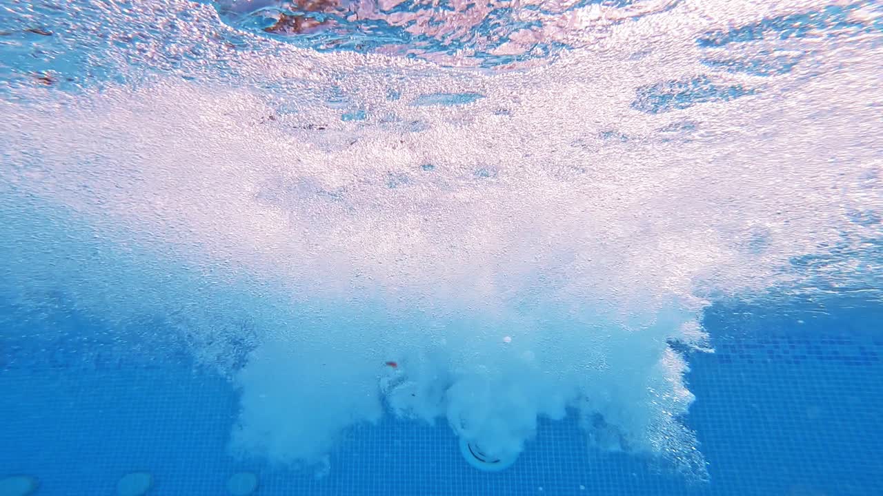 Bubbles rising to the surface. Air bubbles in clear blue water in pool. Many bubbles in the water of the swimming pool. Close-up.