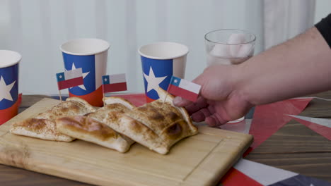 fiestas patrias chile poniendo una empanada y banderas chilenas y terremoto bebida nacional enfoque selectivo
