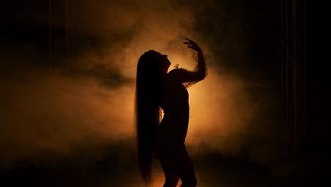 silueta de una mujer bailando en el humo