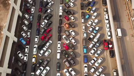 birds eye aerial view of full parking lot, parked cars by road in suburbs of bangkok, thailand, high angle drone shot