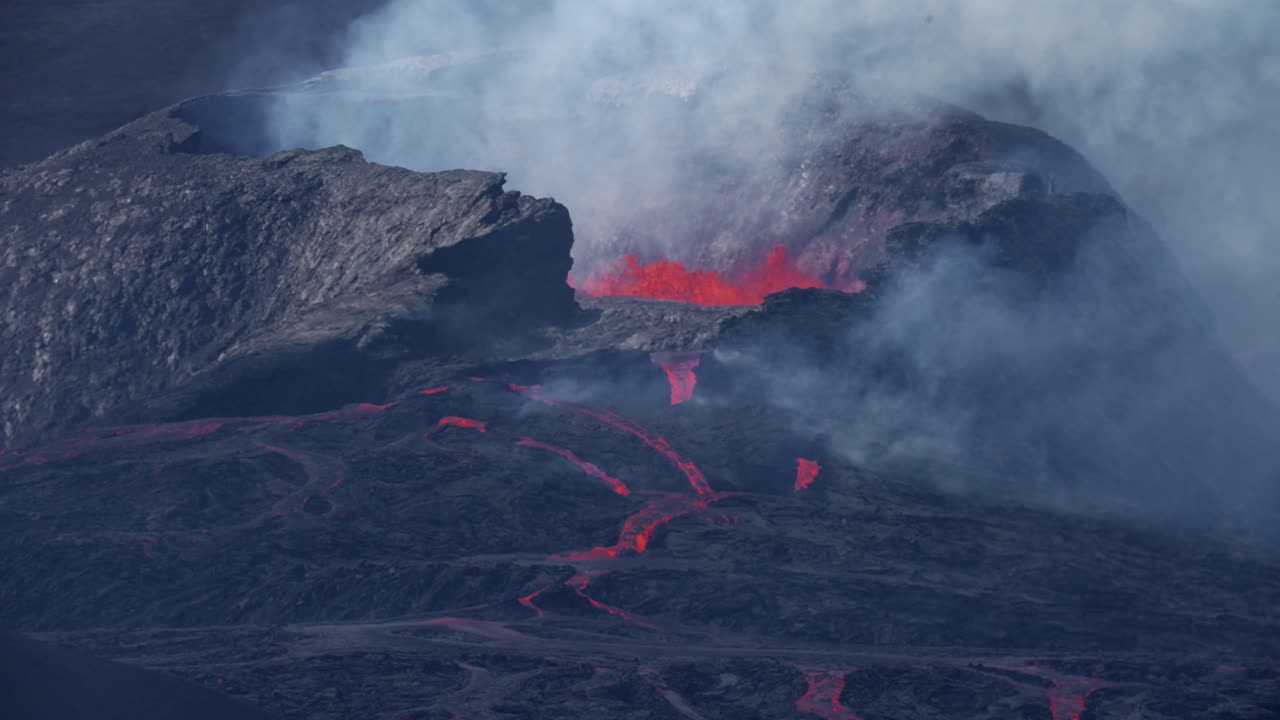 toma amplia en cámara lenta del cráter del volcán arrojando lava de fuego rojo