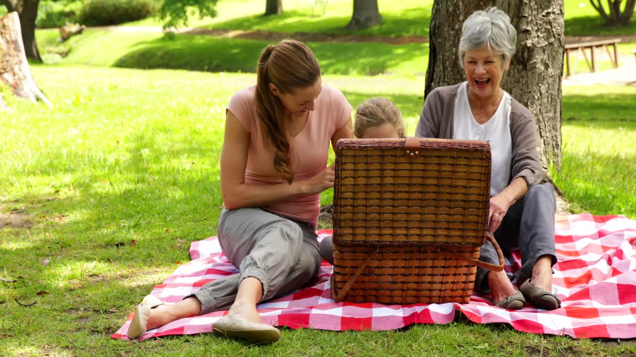 tres generaciones de mujeres teniendo un picnic