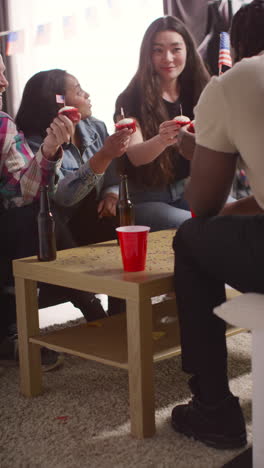 Vertical-Video-Of-Woman-At-Home-Serving-Cupcakes-With-Miniature-American-Stars-And-Stripes-Flags-To-Friends-At-Party-Celebrating-4th-July-Independence-Day-3