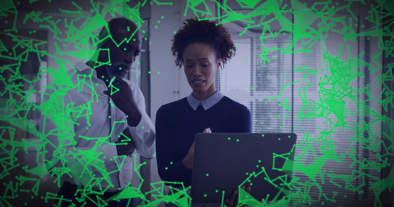 Woman holding laptop, man listening, explaining business data, green overlay drifting over laptop