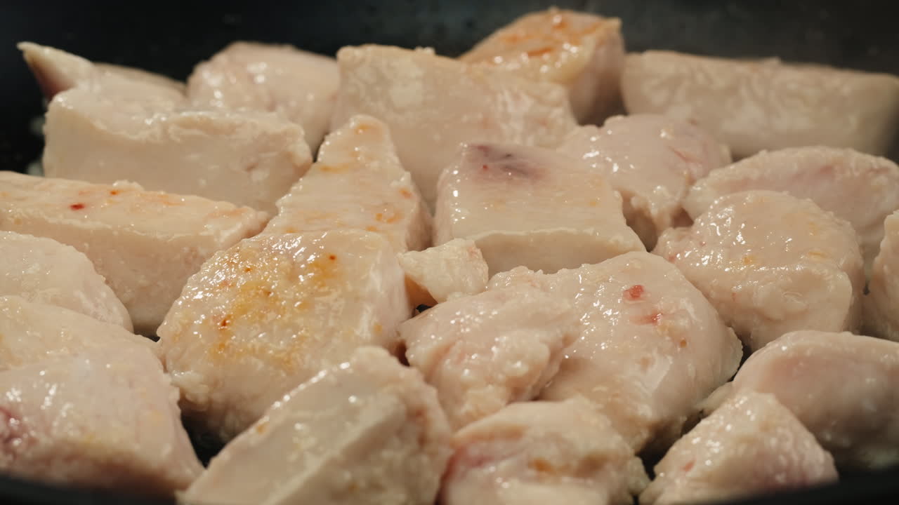 Man slicing raw turkey or chicken meat fillet on oak cutting board closeup, cooking with knife on restaurant kitchen. High quality 4k footage