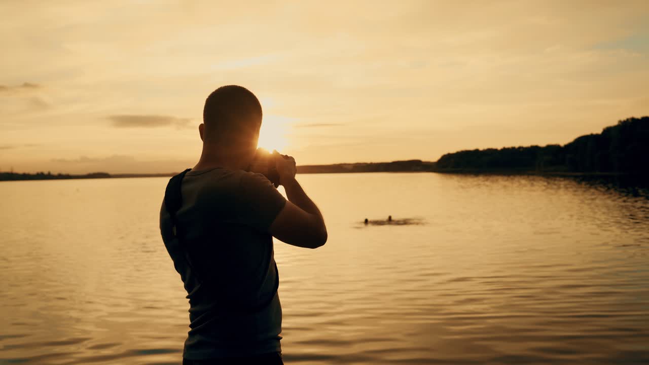 Photographer taking picture of sunset at local beach which is tourists point. Beautiful summer sunset