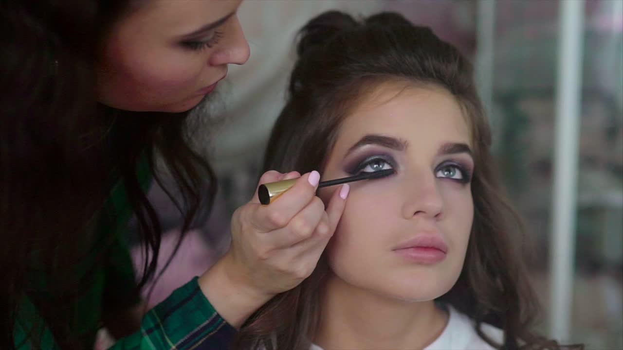 artista de maquillaje aplicando máscara