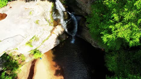 Drone-Bajando-Lentamente-Hacia-Una-Hermosa-Cascada-Y-Formación-Rocosa