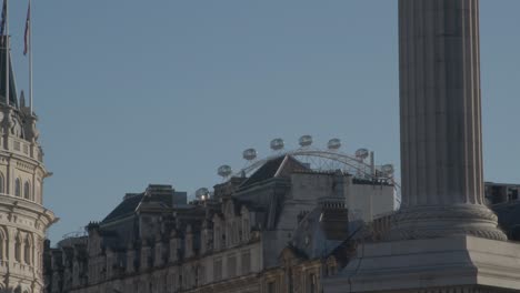 the london eye towering over the city buildings.