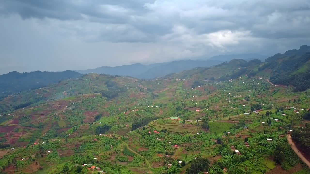 Patchwork farmland and scattered village homes across rolling hills of Kanungu District in the Kigezi Highlands Western Uganda within the Albertine Rift region, slow pull away