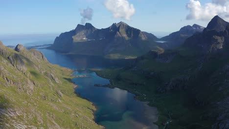 Drone-shot-of-Lofoten-steep-cliffs-and-mountains-rising-from-deep-blue-sea