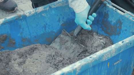 mixing cement in bucket with shovel slow motion