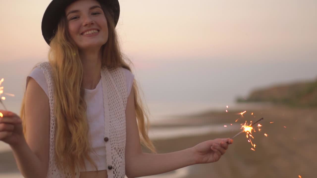 женщина с искрами на пляже заката