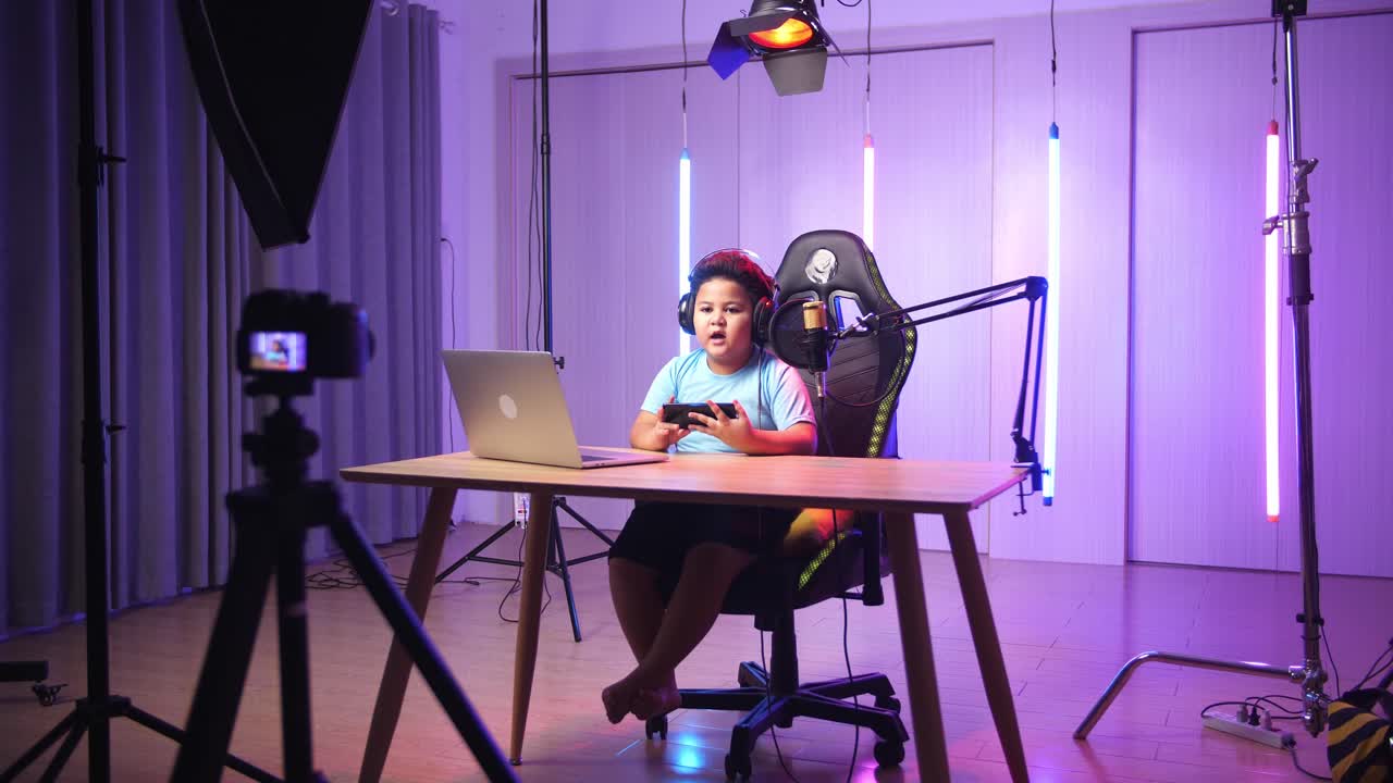 Asian Little Boy Holding Mobile Phone And Talking To Camera While Live Stream, Professional Light Equipment