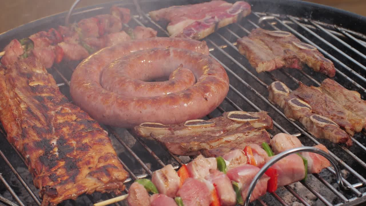 Traditional spanish barbeque, big sausage chorizo botifarra, pork and beef ribs on grill with fire, american style cooking, chef grilling meat fat food, steaks and sausages on bbq. High quality 4k footage