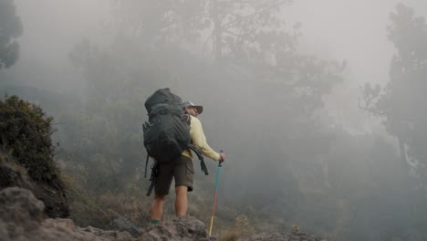 Hiker-With-Backpack-Standing-On-The-Rock-On-Foggy-Morning-In-Acatenango-Volcano