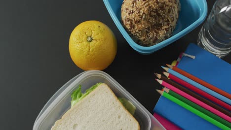 video of healthy packed lunch of fruit and vegetables, with coloured pencils on schoolbag