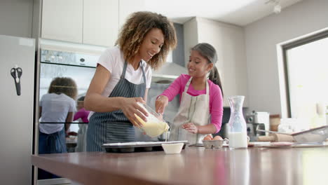 Feliz-Madre-Birracial-E-Hija-Vertiendo-Mezcla-De-Pastel,-Horneando-En-La-Cocina,-Copiando-Espacio,-Cámara-Lenta