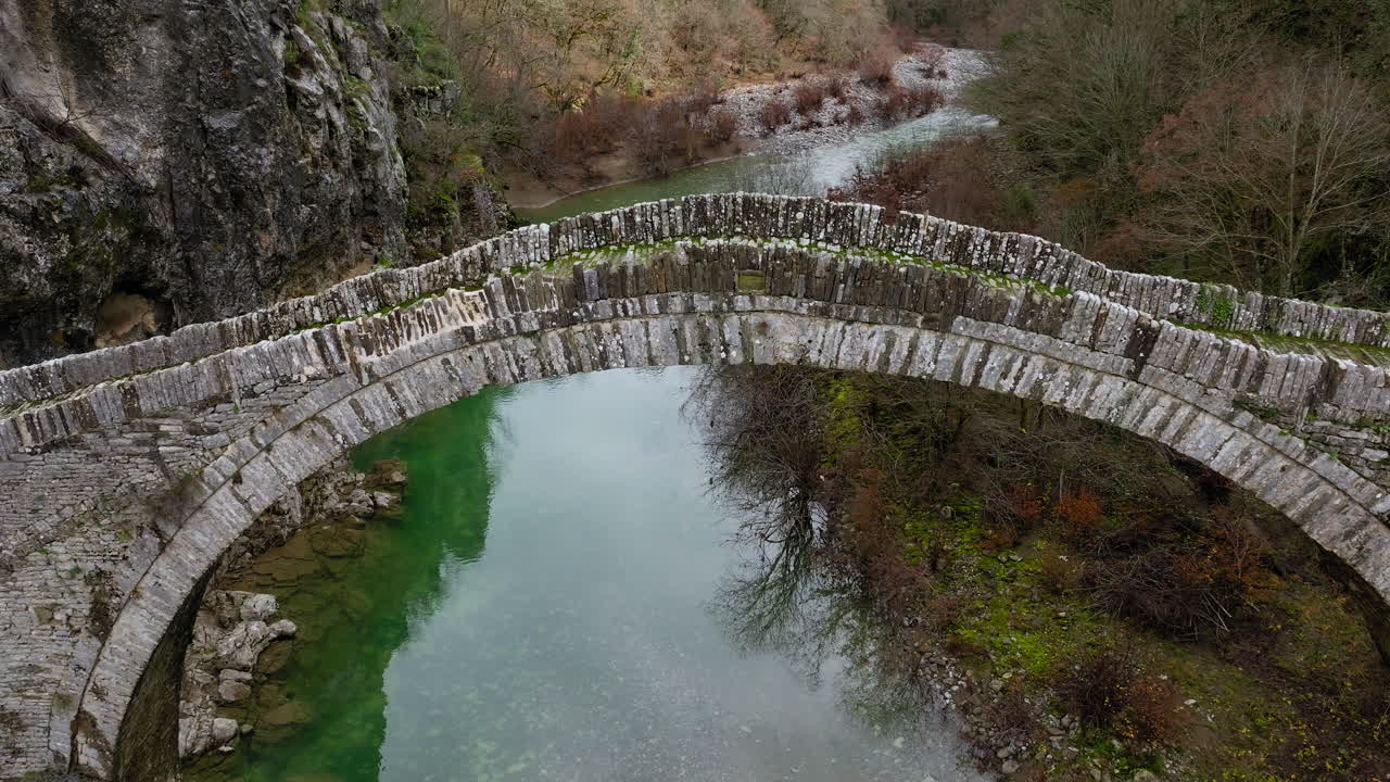 Antico ponte ad arco in pietra di Kokkorou (Kokkoris) su un fiume turchese in Epiro, Grecia, patrimonio.