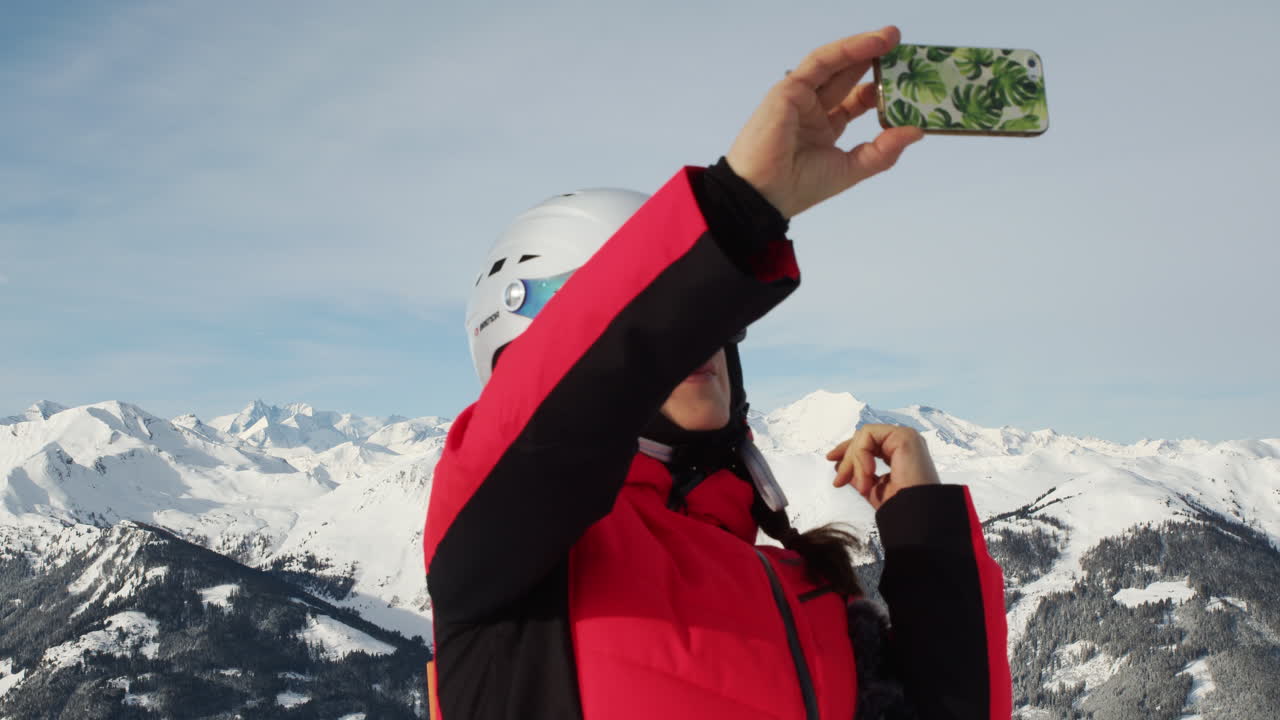una mujer tratando de tomar selfie en la cima de una montaña