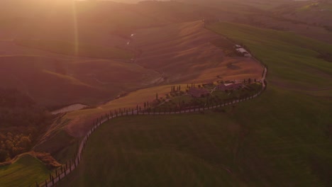 Bright-sunset-at-famous-Cypress-tree-road-in-Italy,-Crete-Senesi,-aerial