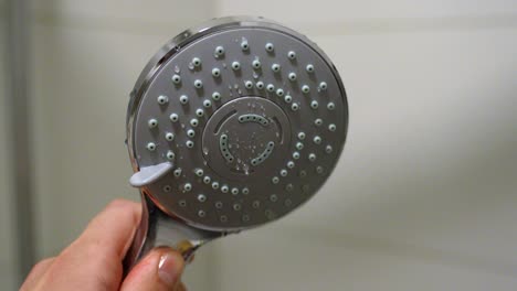 Slow-Motion-Shower-Head-Close-Up-Twisting-and-Turning-in-the-Bathroom-with-a-Blurred-Background