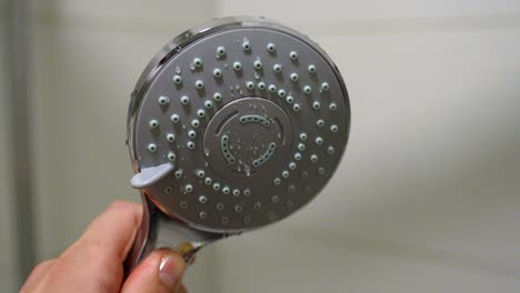 cabeza de ducha en cámara lenta en primer plano girando y girando en el baño con un fondo borroso