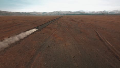 Fast-and-Furious,-SUV-Accelerate-on-dirt-road-to-mountain-landscape