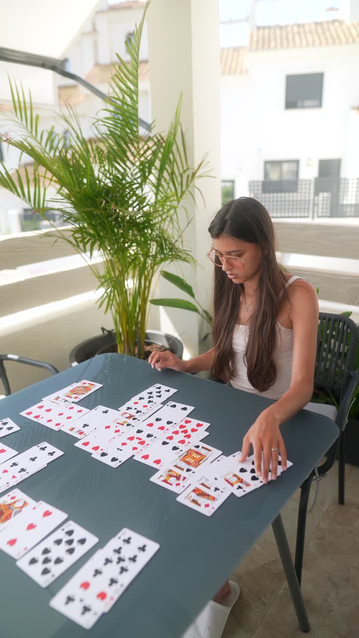 mujer jugando a las cartas al aire libre en un balcón