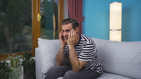 hombre preocupado y nervioso en casa mirando afuera.